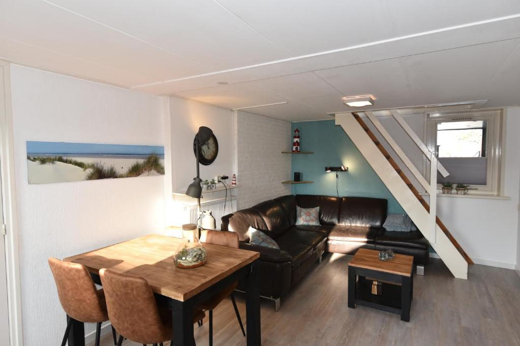 ein Wohnzimmer mit einem Sofa und einem Tisch in der Unterkunft Appartement Tjerk in Hollum