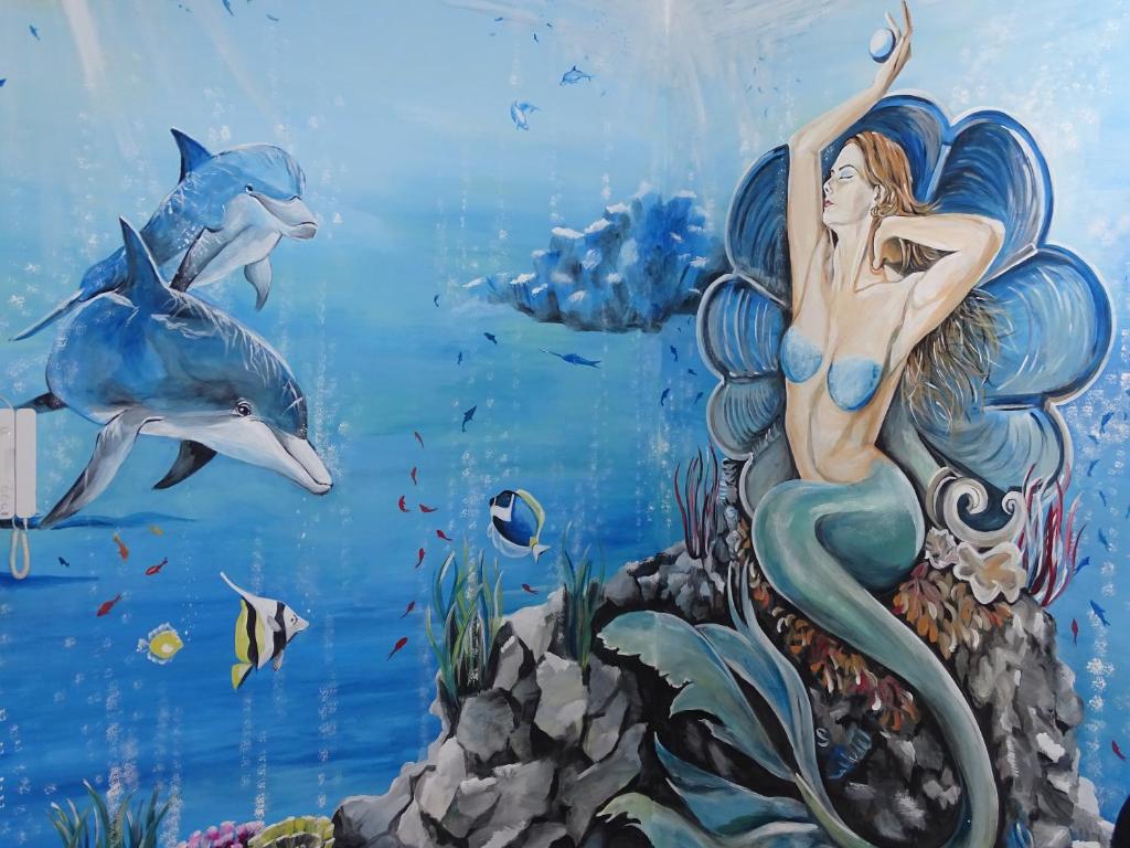 een muurschildering van een zeemeermin in de oceaan bij Perla del Sud in Villa San Giovanni