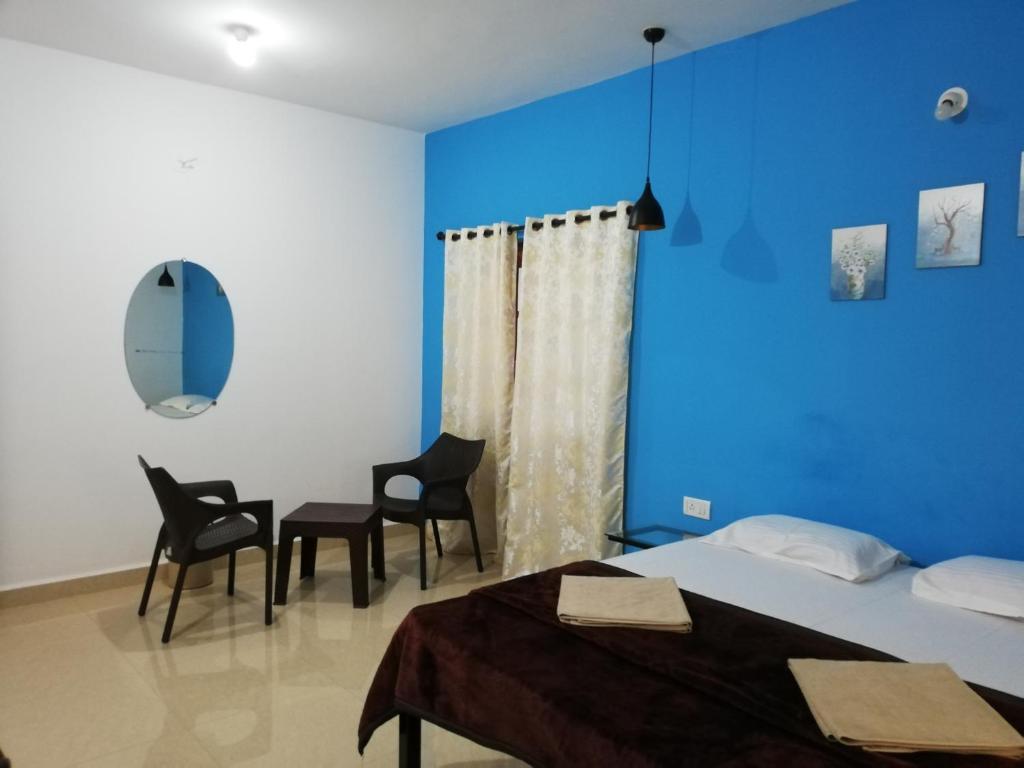 a room with two beds and a table and chairs at Sabinas Goa in Saligao