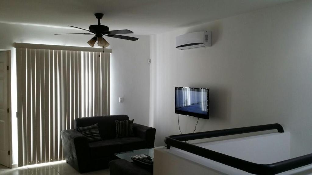- un salon avec un canapé et un ventilateur de plafond dans l'établissement AIRPORT SHORT & LONG TERM EXPRESS ALMERIA x, à Monterrey