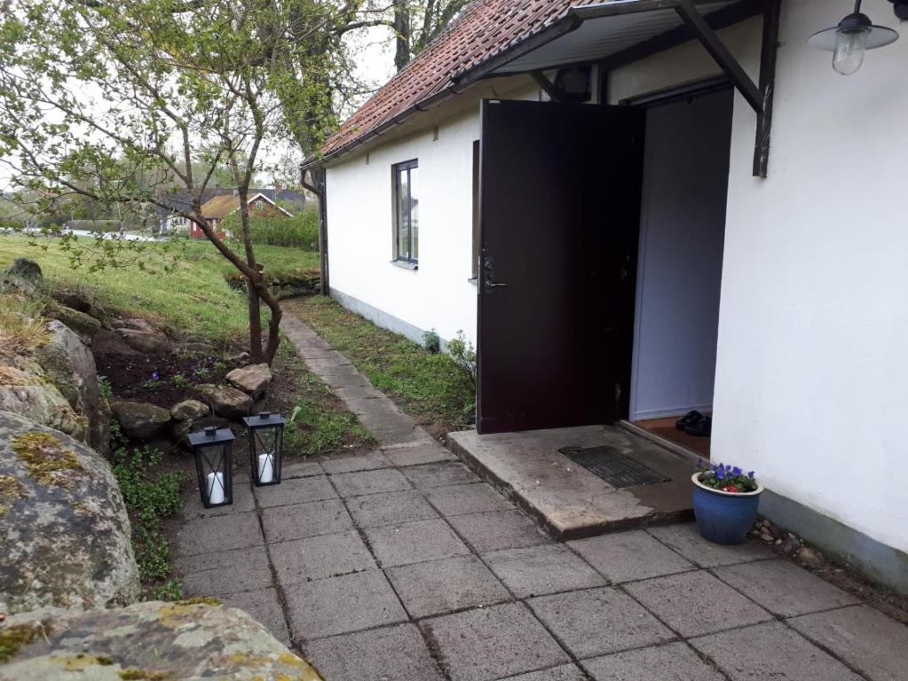 eine Tür zu einem weißen Haus mit einem Hof in der Unterkunft Brösarps Norra Backar in Brösarp