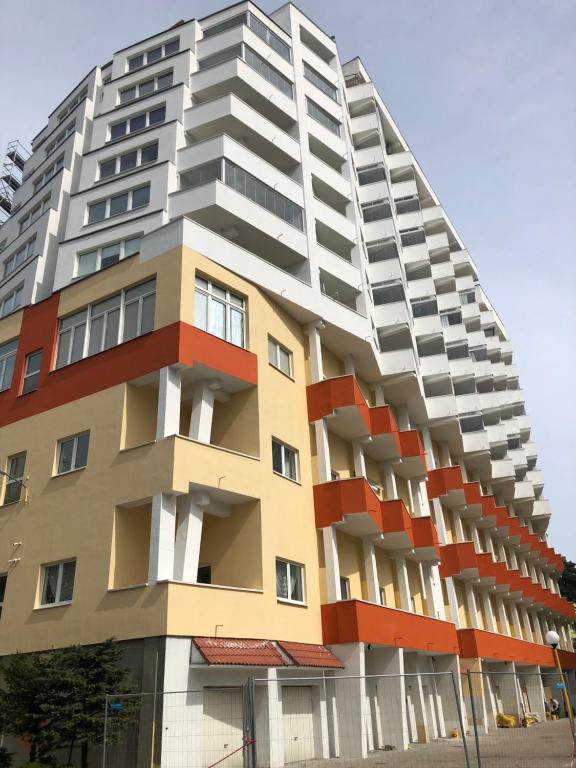 ein großes Apartmenthaus mit roten und weißen Balkonen in der Unterkunft Apartament Julia in Misdroy