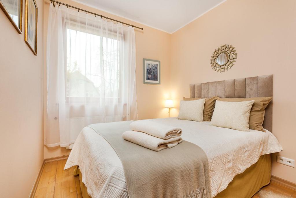 1 dormitorio con 1 cama grande y ventana en Apartament Laguna, en Sopot