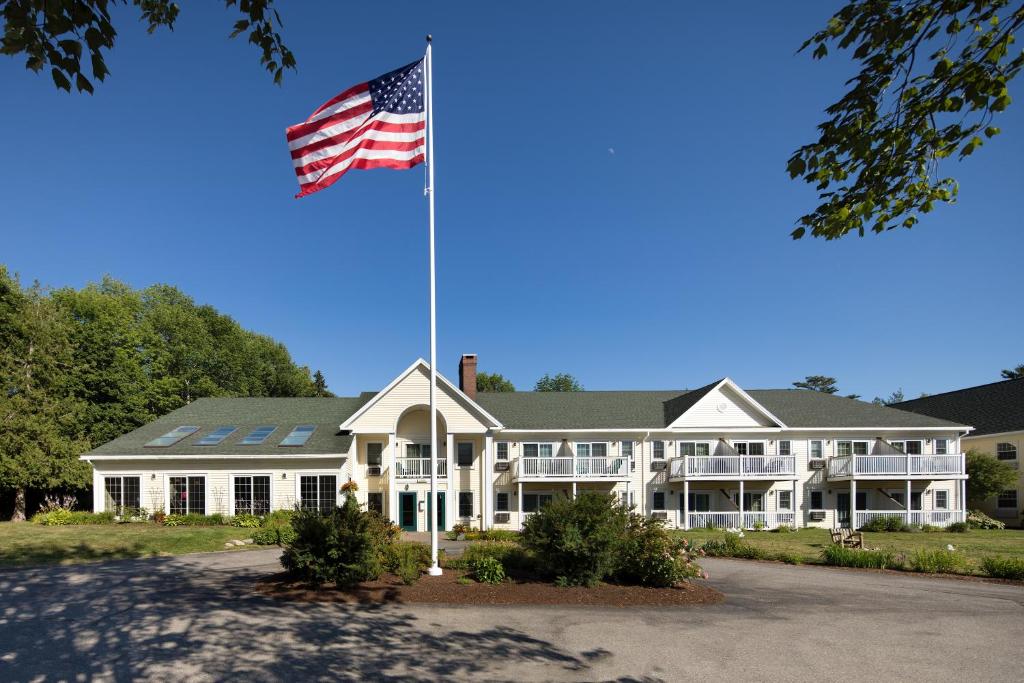 uma bandeira americana a voar em frente a uma casa grande em Country Inn at Camden Rockport em Rockport