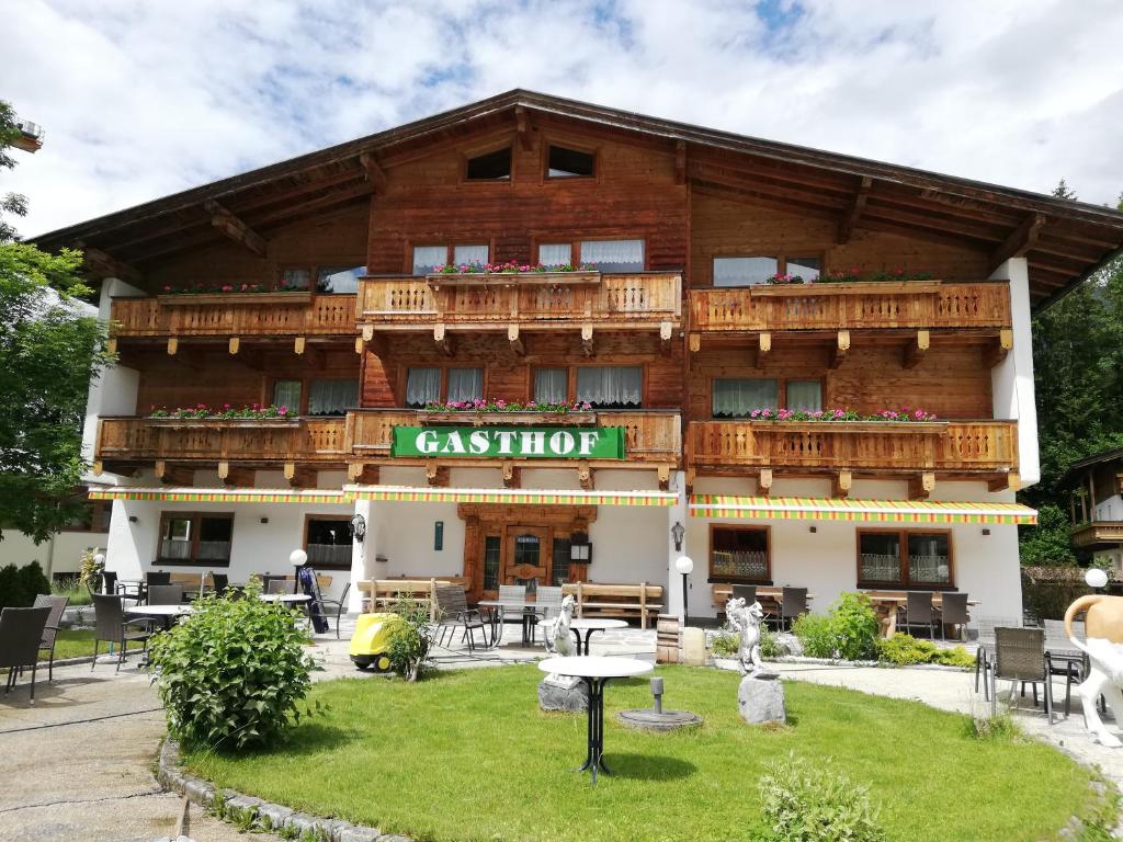 un grand bâtiment avec un panneau indiquant un restaurant dans l'établissement Scheffauerhof, à Scheffau am Wilden Kaiser