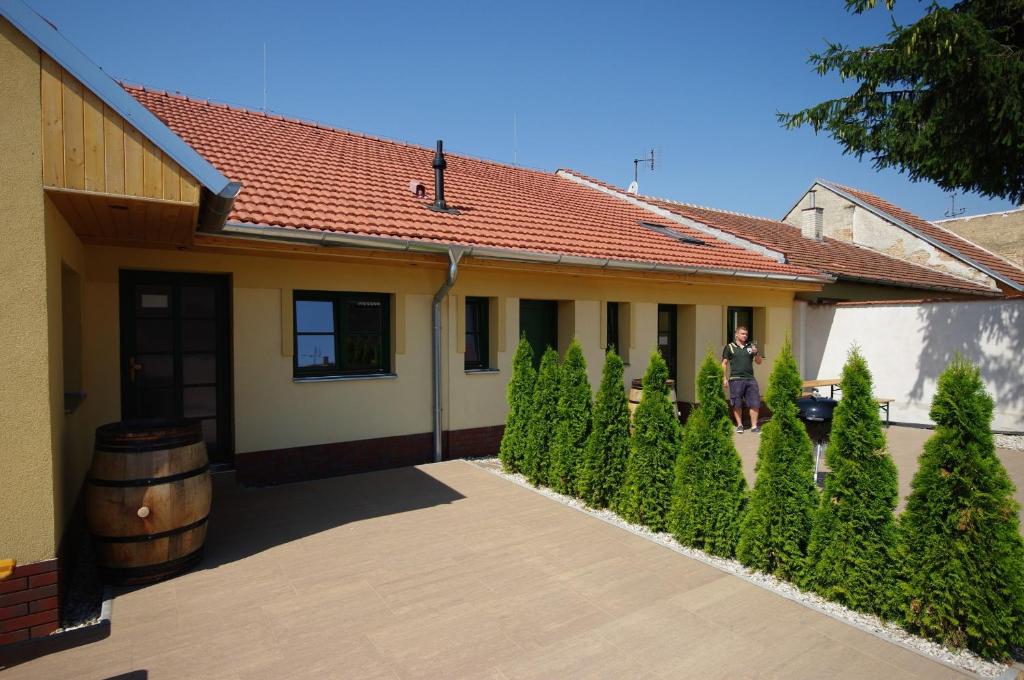 a person standing in front of a house with a barrel at Pension Max Valtice in Valtice