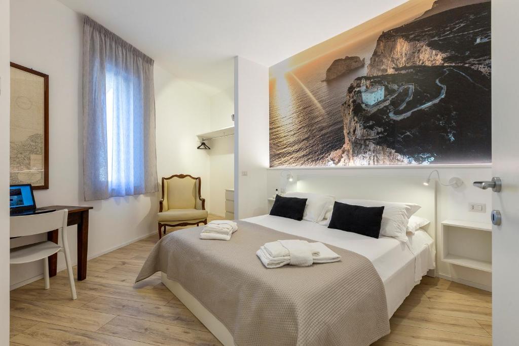 RelaisApartments MERCEDE - Extraordinary Hospitality في ألغيرو: غرفة نوم بسرير ومكتب وجهاز كمبيوتر