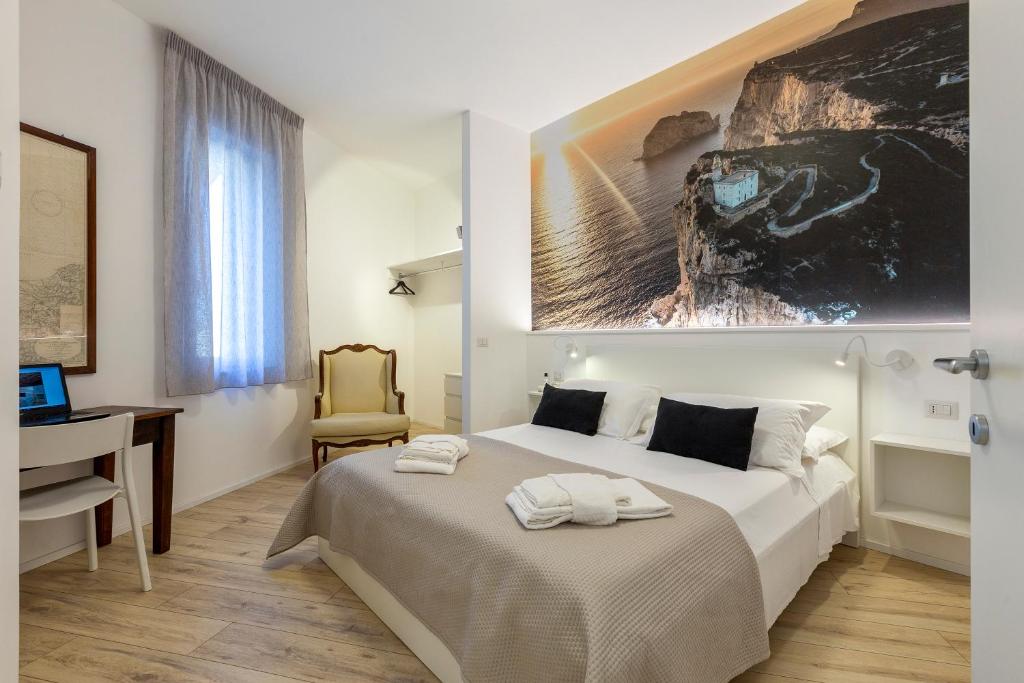 una camera con letto, scrivania e computer di RelaisApartments MERCEDE - Extraordinary Hospitality ad Alghero