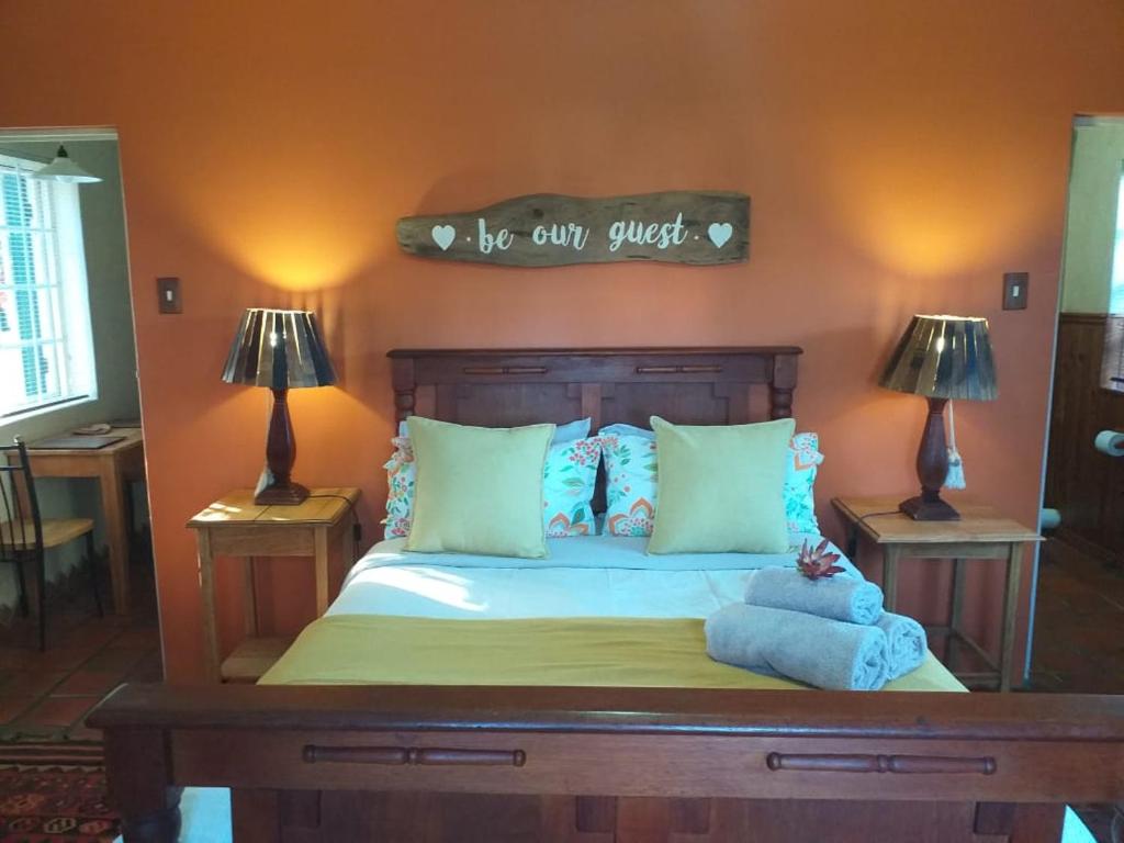 a bedroom with a bed with a sign on the wall at Sol Y Sombra in Bettyʼs Bay