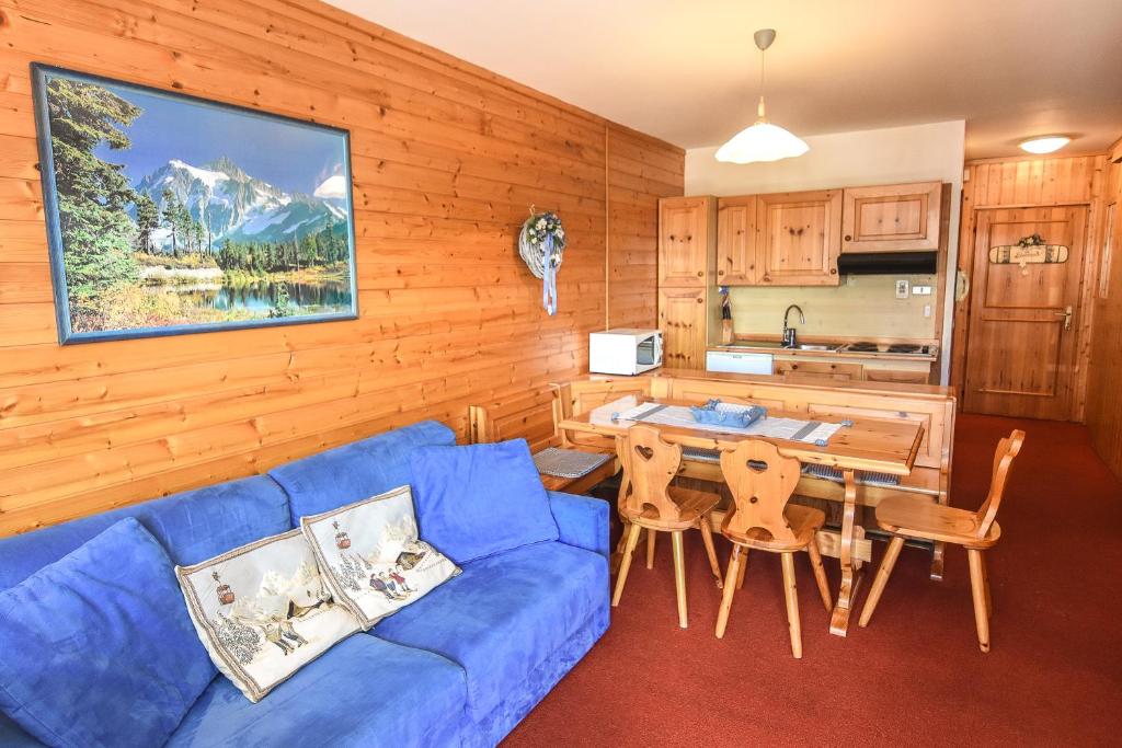 a living room with a blue couch and a table at Appartamenti Dolomiti con wellness in Cavalese