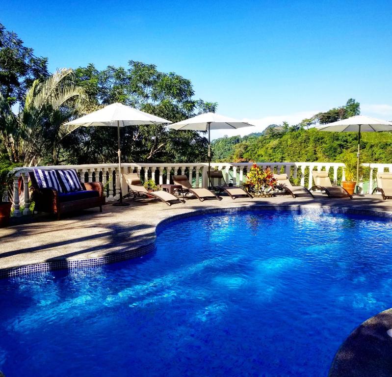 einen Pool mit Stühlen und Sonnenschirmen auf einer Terrasse in der Unterkunft Mango Tree Villas in Coronado