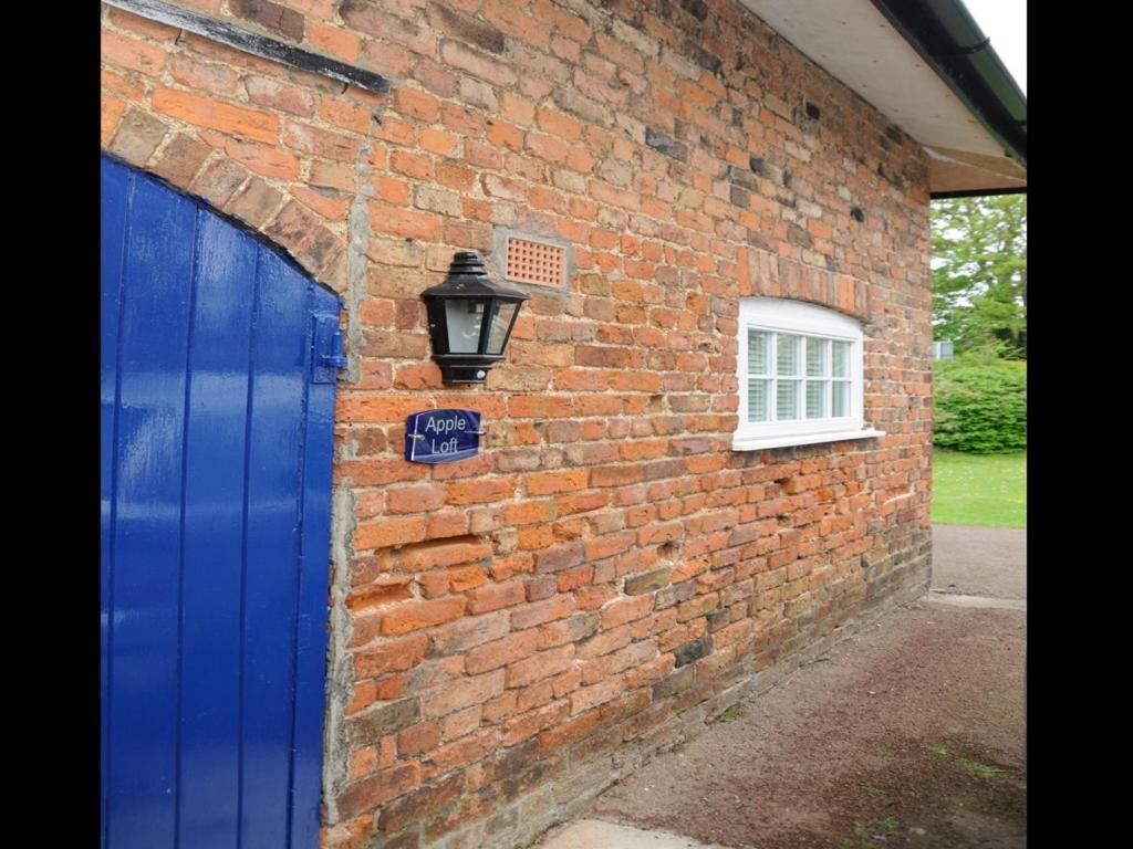 a brick building with a blue door and a street light at Apple Loft in Alford