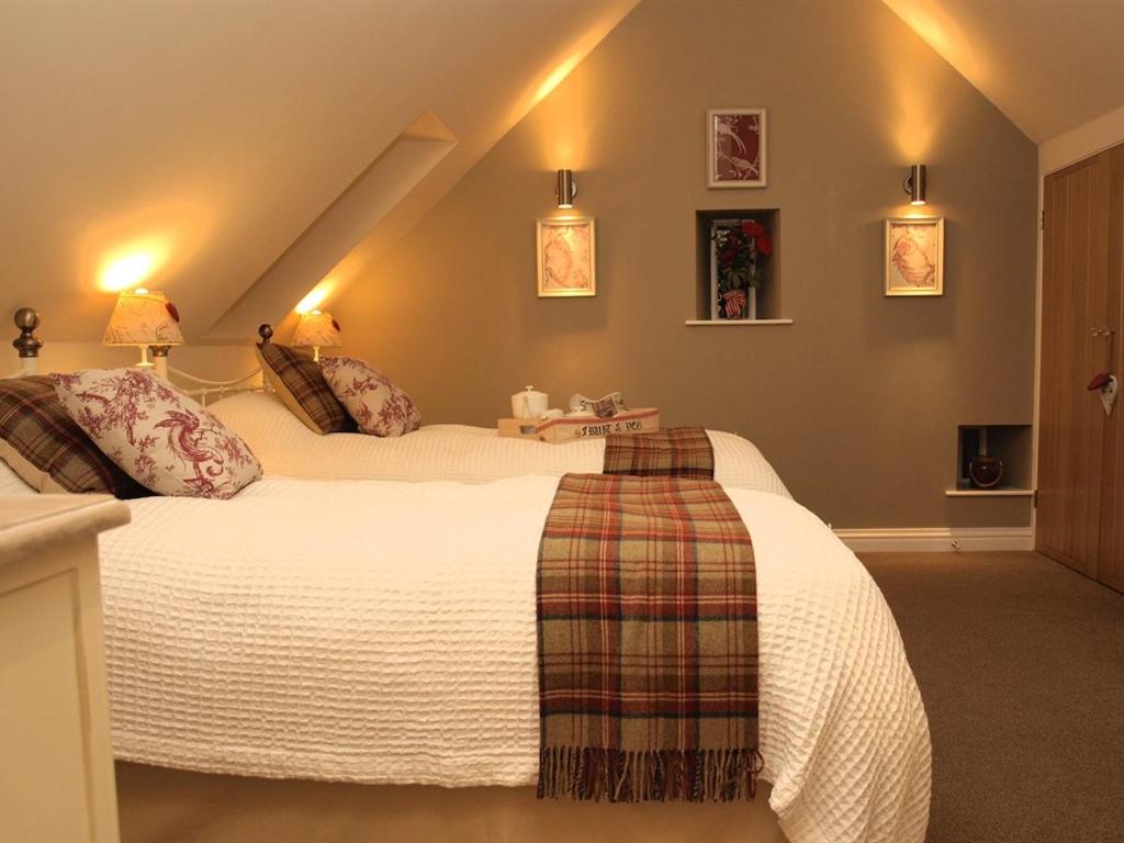 a bedroom with a large bed in a attic at Plum Tree Cottage in Witton le Wear