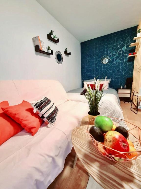 - une table avec un bol de fruits sur le lit dans l'établissement Cosy Appart Hotel Boulogne -Paris, à Boulogne-Billancourt
