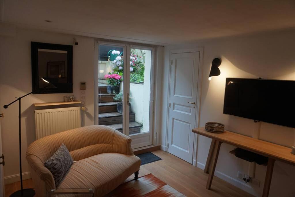 a living room with a chair and a television at Le calme à 2 pas de Paris in Levallois-Perret
