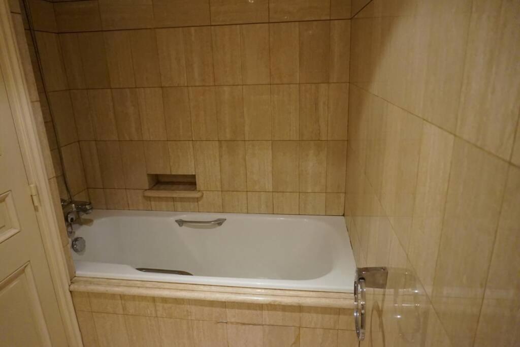 a bath tub in a tiled bathroom with a bath tub at Le calme à 2 pas de Paris in Levallois-Perret