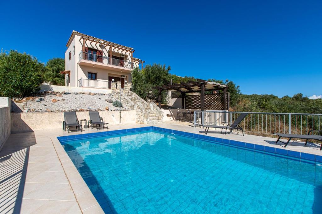 a swimming pool in front of a house at Villa Alexey Homeleader in Tavronitis