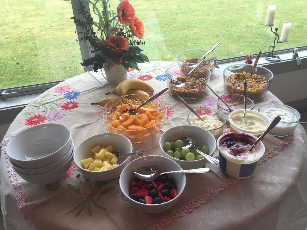 une table avec des bols de fruits et autres denrées alimentaires dans l'établissement Taranaki Country Lodge, à New Plymouth