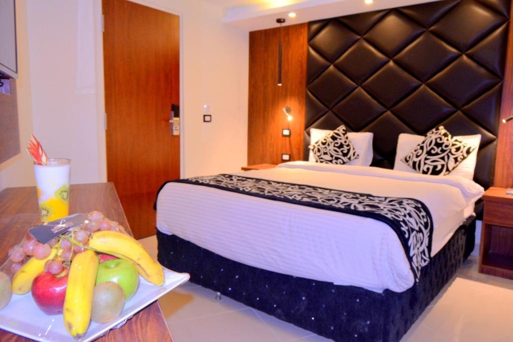 um quarto de hotel com uma cama e uma bandeja de frutas em Panorama Ramsis Hotel & Cafe no Cairo