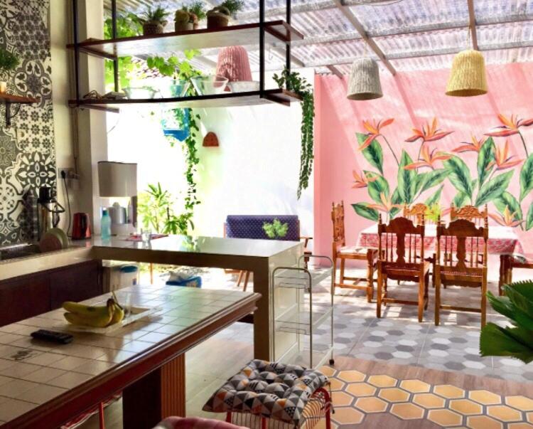 sala de estar con mesa y algunas plantas en Summergrass B&B, en Yogyakarta