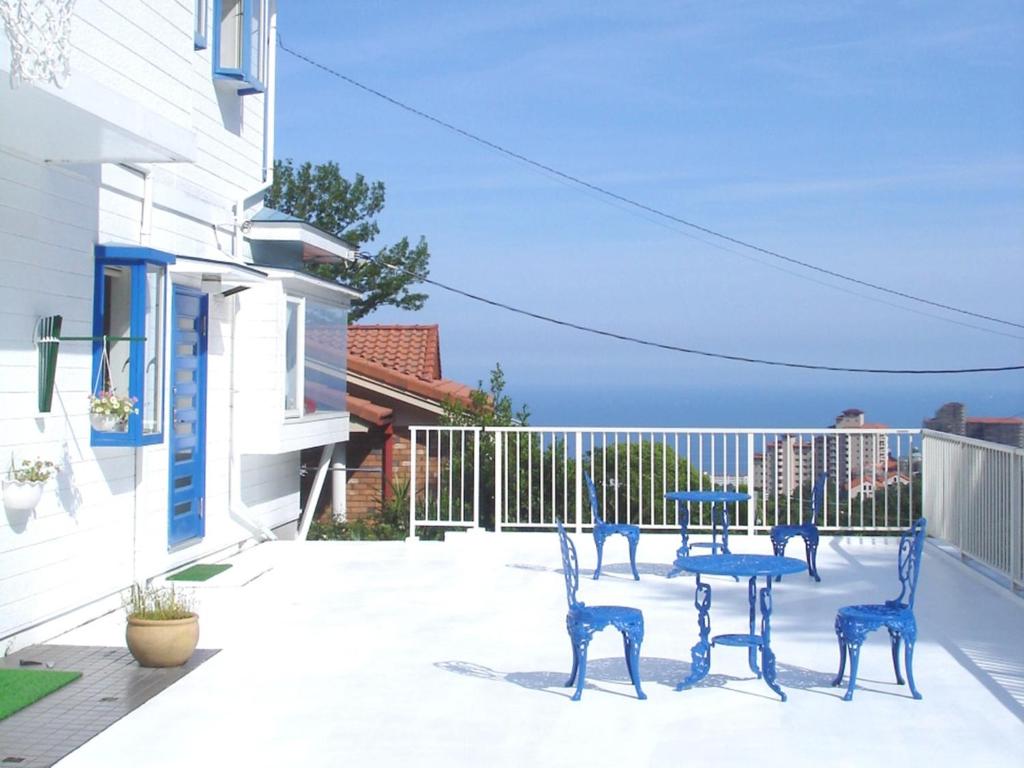 a patio with three blue chairs and a table at Kamo-gun - Hotel / Vacation STAY 50723 in Okawa