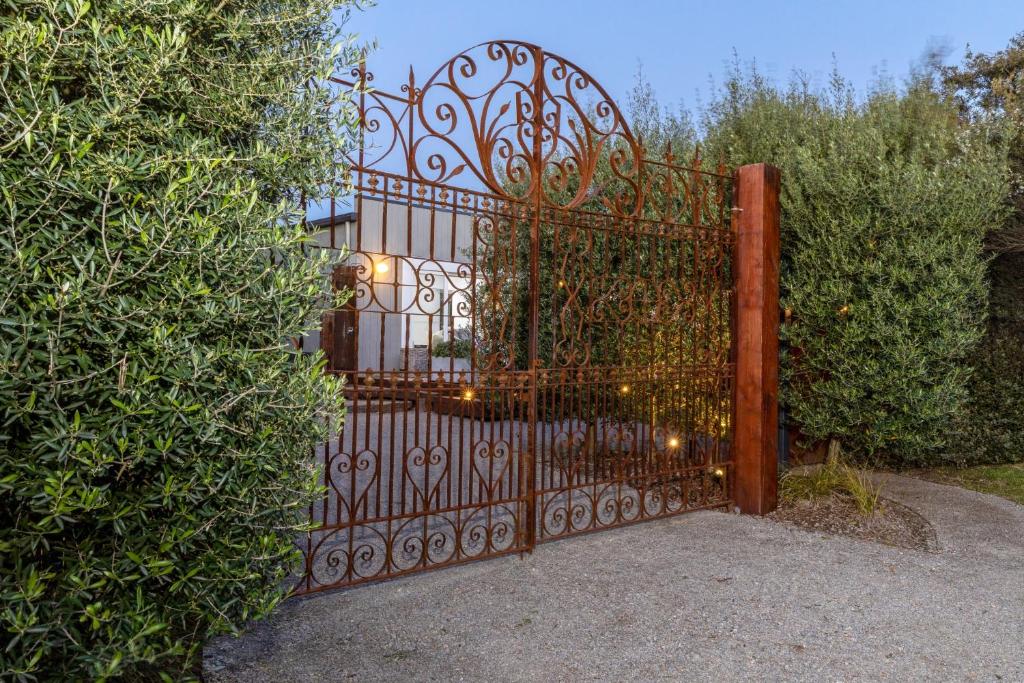 a gate in a yard with a large bush at Grand Capella Villa 1 in Blairgowrie
