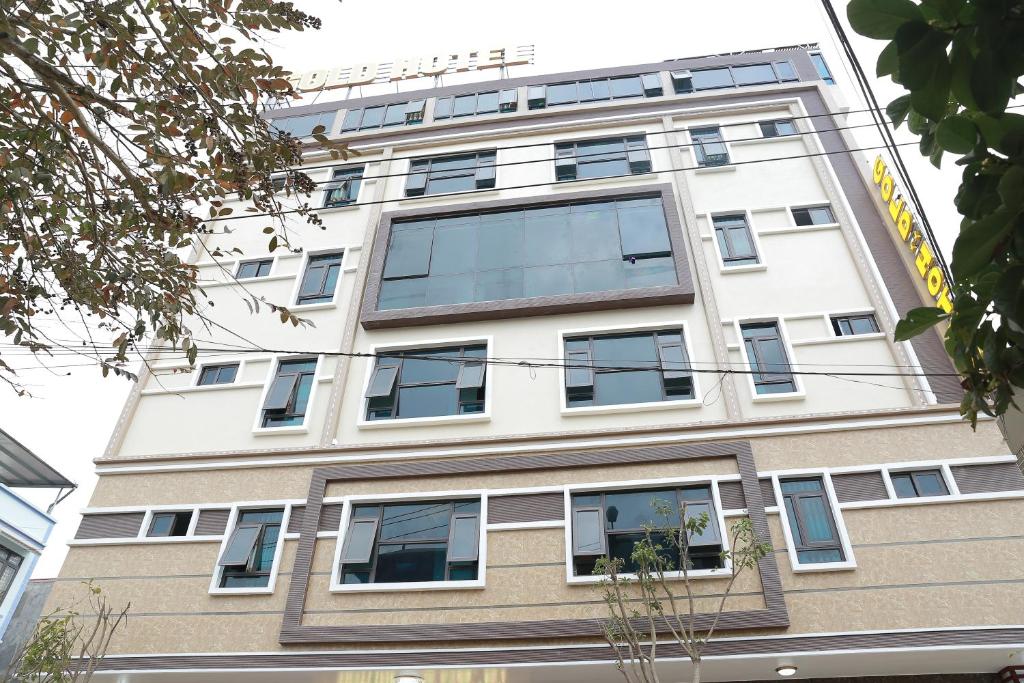 a tall white building with windows at Gold Hotel in Cao Bằng