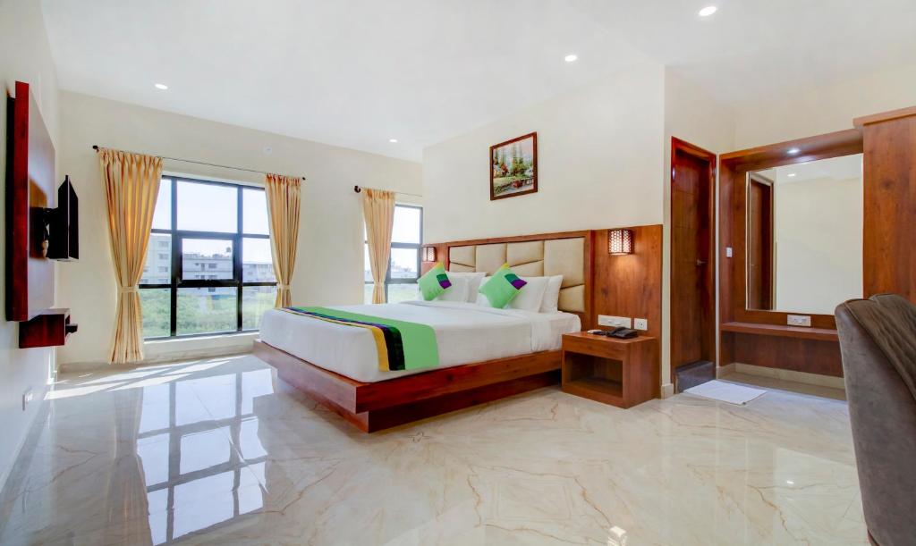 a bedroom with a bed and a large window at Treebo The Meridian in Chikmagalūr