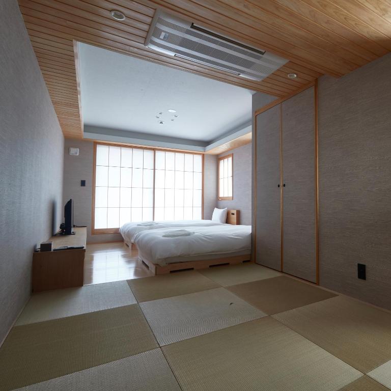 Postel nebo postele na pokoji v ubytování KAMAKURA Hotel