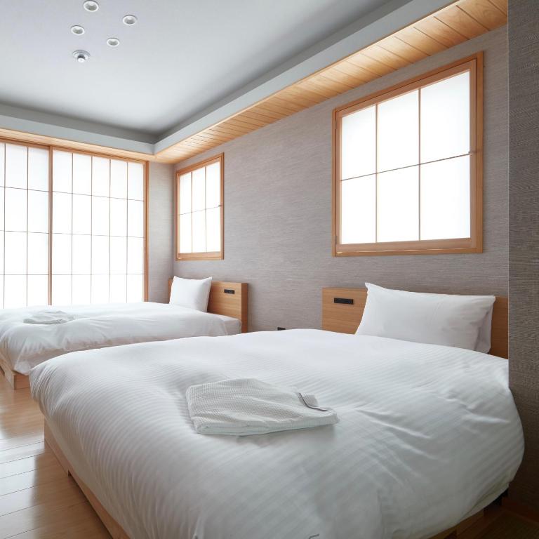 Postel nebo postele na pokoji v ubytování KAMAKURA Hotel