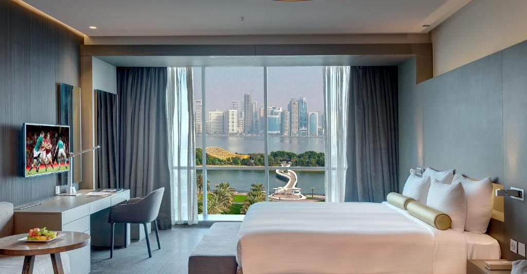 シャルジャにある72 Hotel Sharjahの大きなベッドと窓のあるホテルの部屋