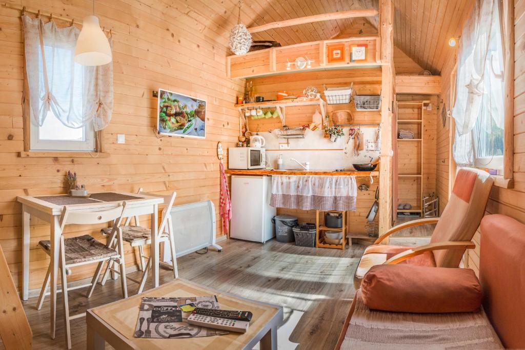 a kitchen and living room in a log cabin at Tiny House Lavender in Podtureň