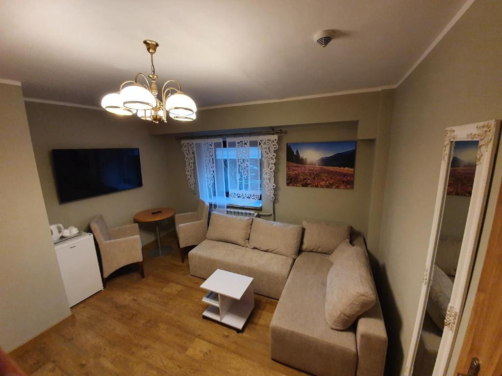 ein Wohnzimmer mit einem Sofa und einem Tisch in der Unterkunft Pokoje Gościnne Zakopane in Zakopane