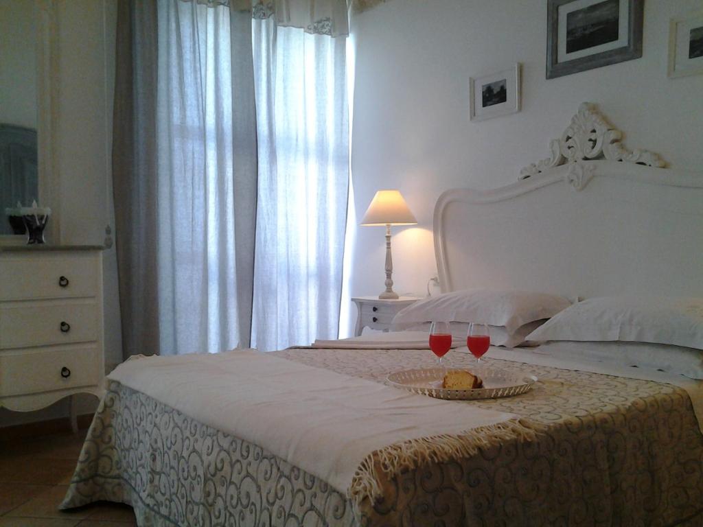 um quarto com uma cama com dois copos de vinho em B&B La Porta Vecchia em Monopoli