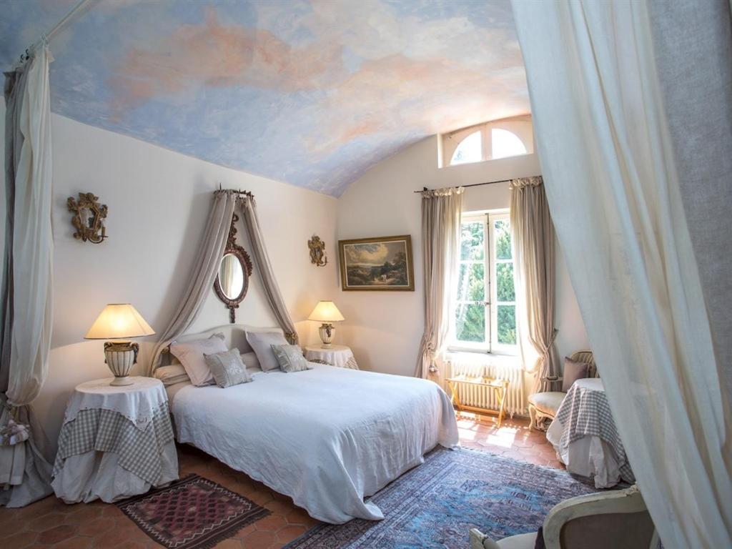 a bedroom with a bed with a painting on the ceiling at Chateau de la Rue in Cour-sur-Loire