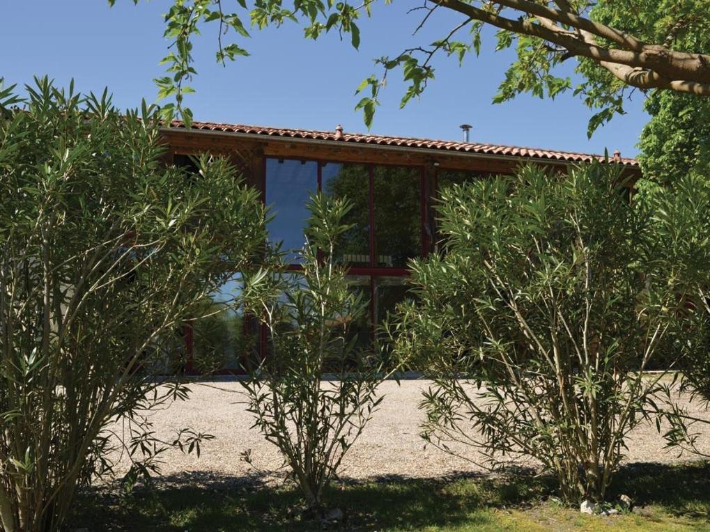 a house is seen behind some bushes at Domaine de Quittignan Brillette in Moulis-en-Médoc