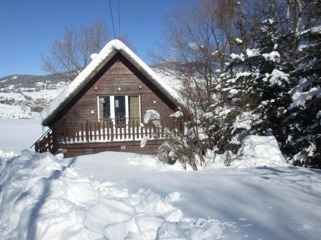 a log cabin in the snow with a tree at chalet ST PIERRE DELS FORCATS in Saint-Pierre-dels-Forcats