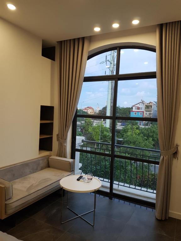 a living room with a couch and a large window at Vinhomes Imperia in Hai Phong