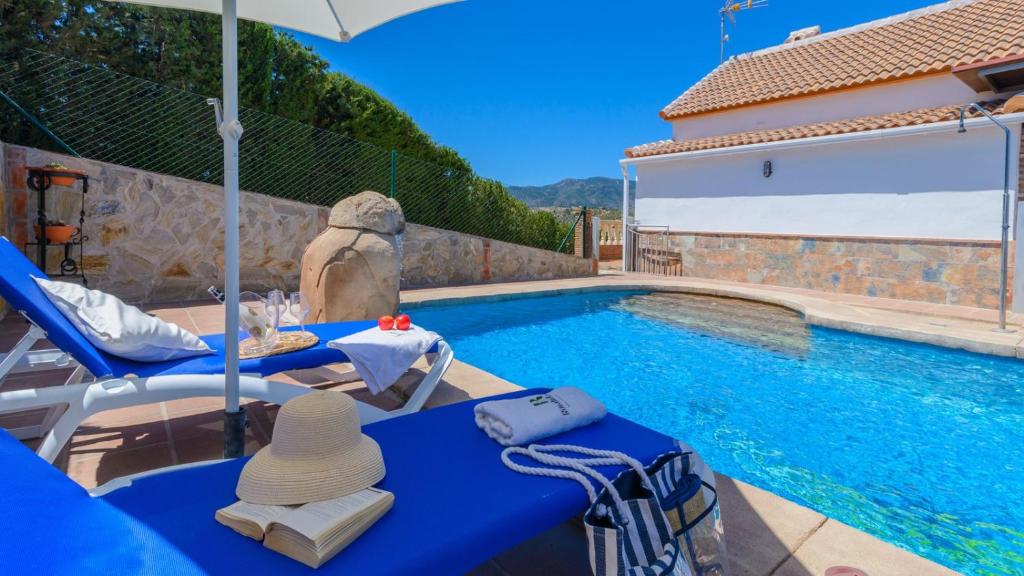 Cette villa dispose d'une piscine avec 2 chaises et un parasol. dans l'établissement Casa Los Valles Alozaina by Ruralidays, à Alozaina
