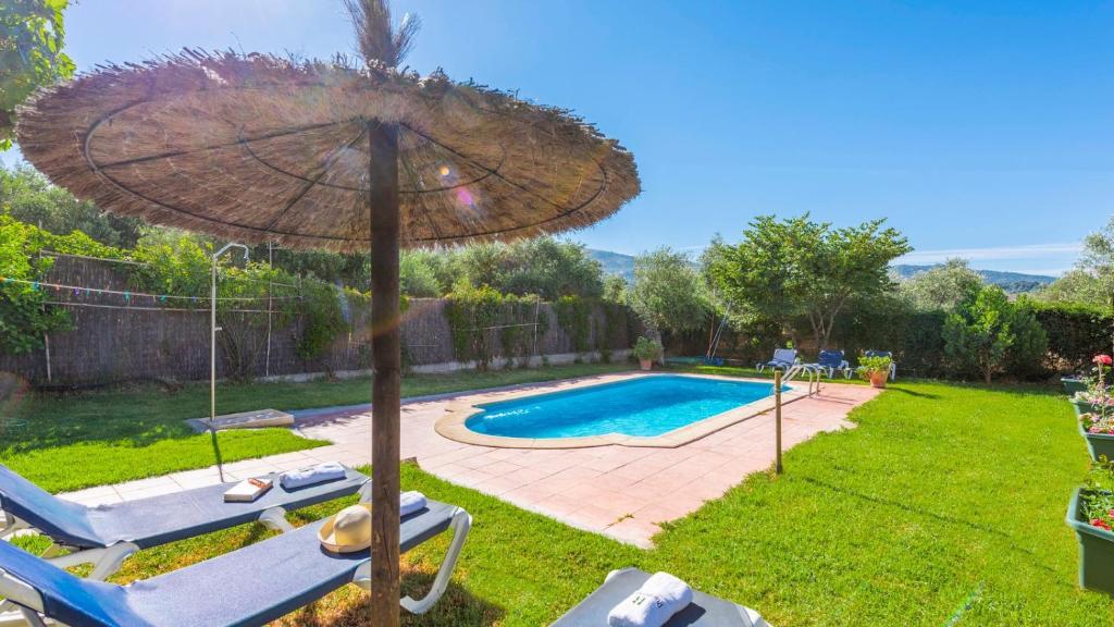 a backyard with a swimming pool and an umbrella at Villa Andrea Cortes de la Frontera by Ruralidays in Cortes de la Frontera
