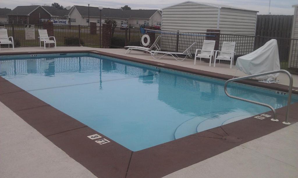 a large swimming pool with chairs at GuestHouse Inn Dothan in Dothan