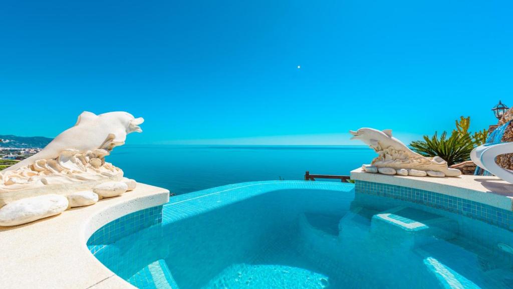 een zwembad met beelden aan de zijkant van een huis bij Casa Ventanas al Mediterraneo Nerja by Ruralidays in Nerja
