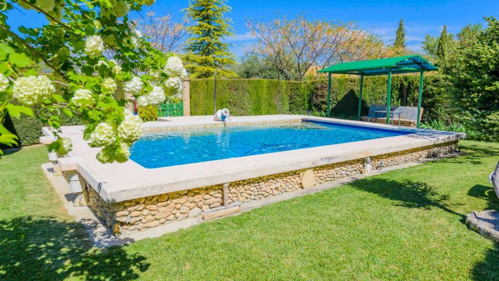una piscina en un patio con una pared de piedra en Casa El Vegetal Arriate by Ruralidays, en Arriate