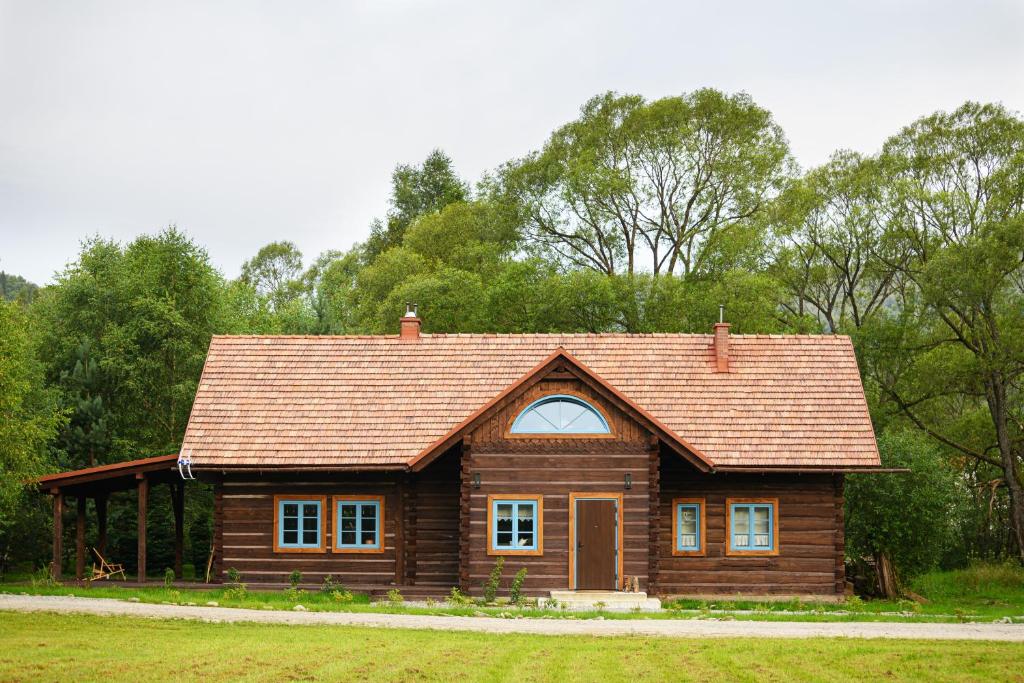 domek z bali z brązowym dachem w obiekcie Gata Blanca w Wetlinie