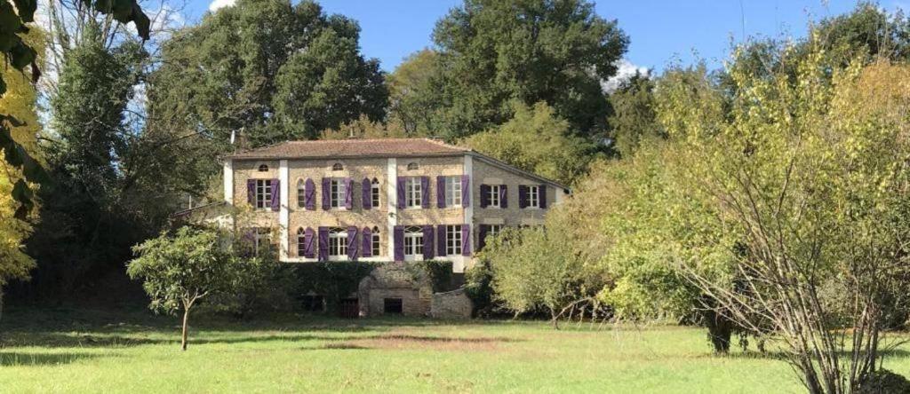 a large house in the middle of a field at Les Volets Violets in Salles