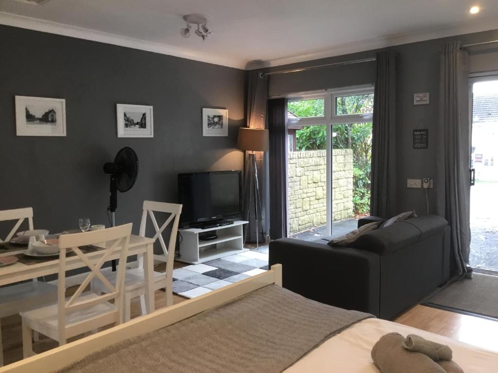 uma sala de estar com um sofá e uma sala de jantar em Self-contained Apartment em Corsham