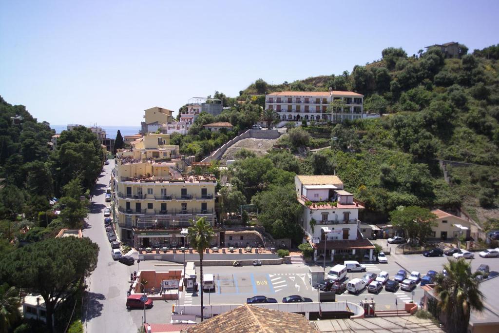 een stad op een heuvel met auto's geparkeerd op een parkeerplaats bij Hotel Villa Bianca Resort in Taormina