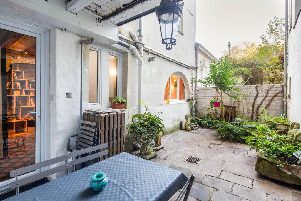 un patio avec une table bleue et un bâtiment dans l'établissement Le Cours Saint Pierre - Entre Château et Cathédrale, à Nantes