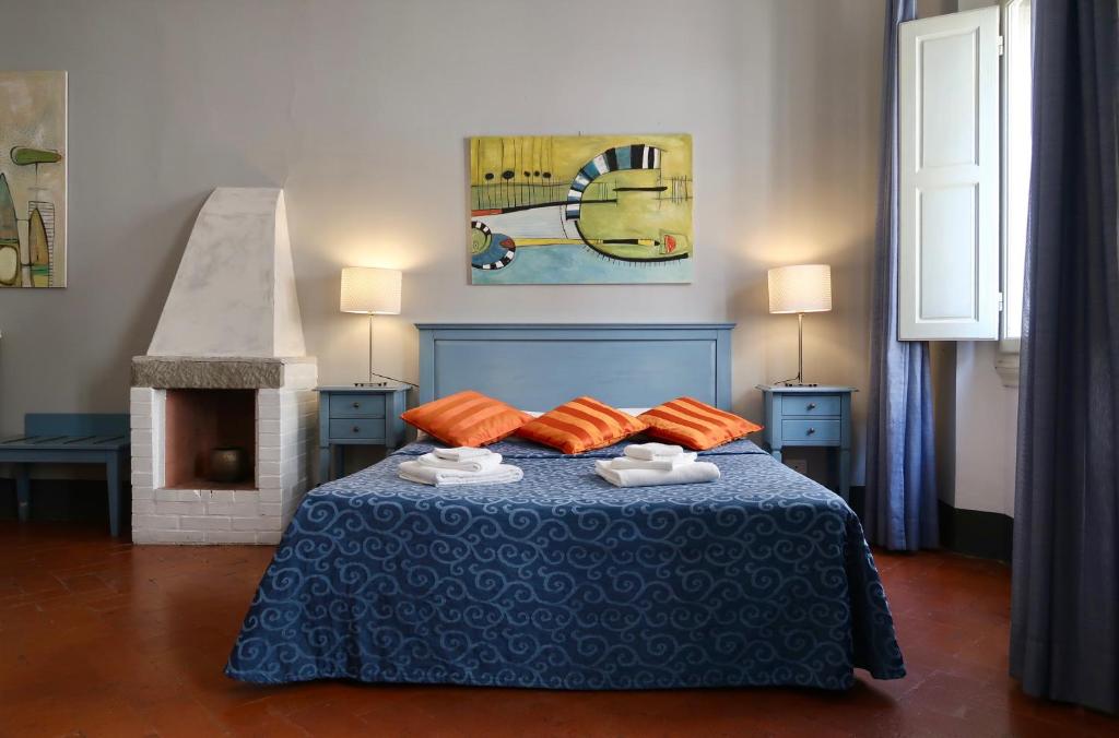 a bedroom with a blue bed with orange pillows at Locanda Della Musica in Florence