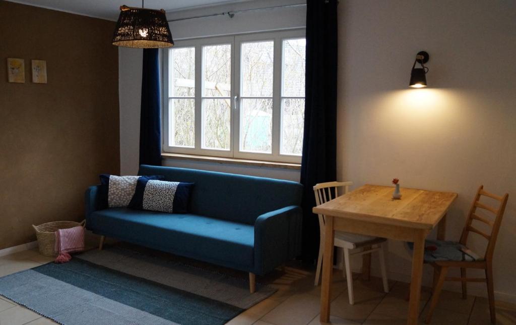 a living room with a blue couch and a table at Ferienwohnung am See in Ottersberg